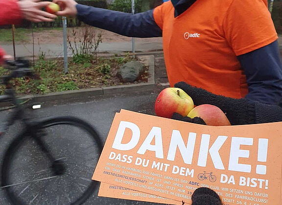 Flyer mit dem Wort Danke wird an Radfahrer ausgeteilt.