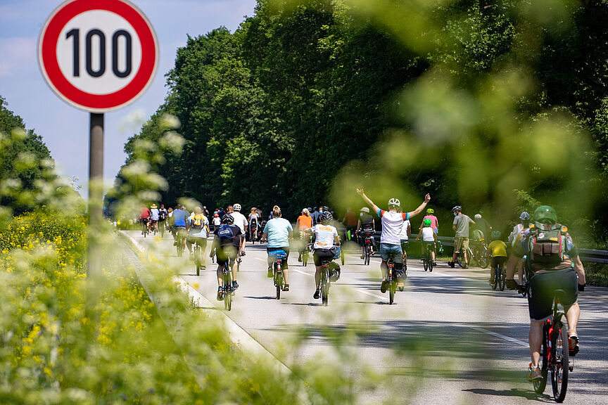Sternfahrt Berlin Radfahrer bei Sternfahrt neben Schild zu Geschwindigkeitsbegrenzung 100h/km