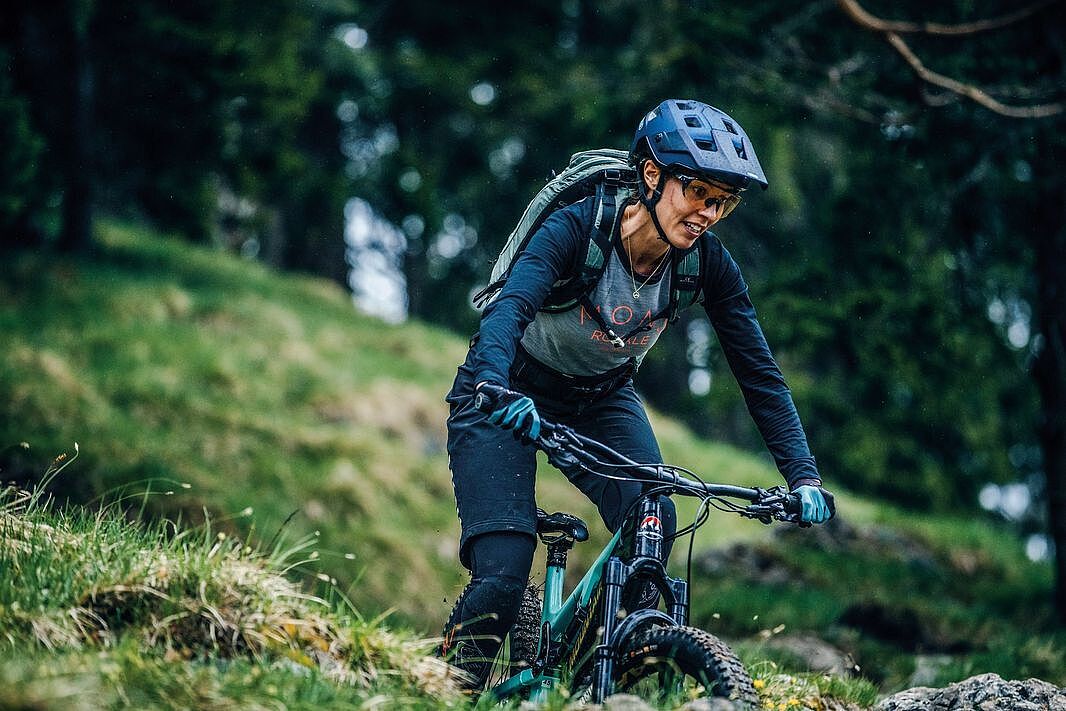 Mountainbike-Helm  Frau auf einem Mountainbike im Wald mit Helm